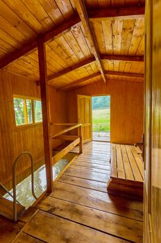 entrance to the bath with a wooden sun lounger and access to the pool