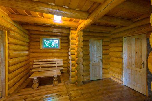 Inside the building, made of a log house, with several doors and a small window