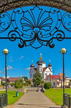 The wrought-iron arch above the entrance to the alley and the beautiful church in the background