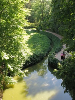 Decorative moat, growing into a lake near a walking alley for tourists