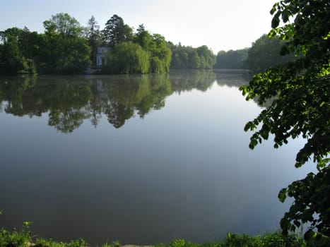 morning in the park on the quiet water surface of the pond