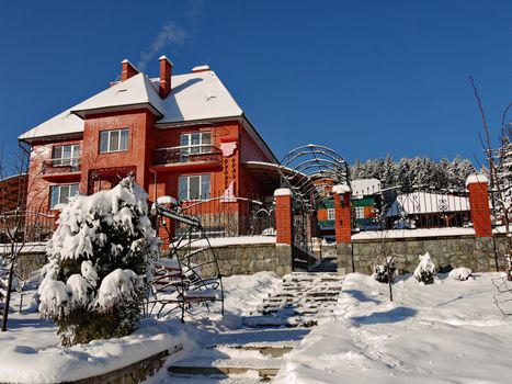 Beautiful two-storeyed villa from a red brick strewn with white snow