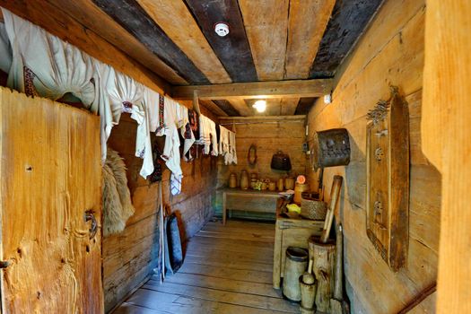 The room is decorated in wood and made in Ukrainian style. It looks like a pantry with stupas, antique utensils and embroidered towels