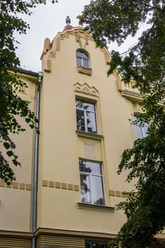 facade of a beautiful building against the background of green leaves