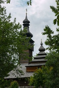 An old church with wooden domes in Transcarpathia in a green park