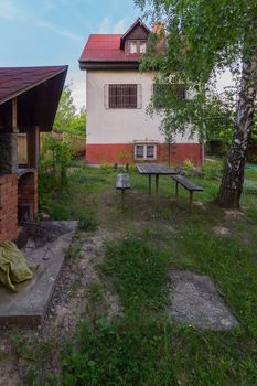 A table with benches in a rural yard. Sit quietly in the evenings