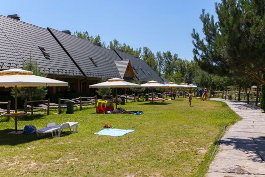 Cottages with panoramic windows on the roof with umbrellas in the yard for vacationers