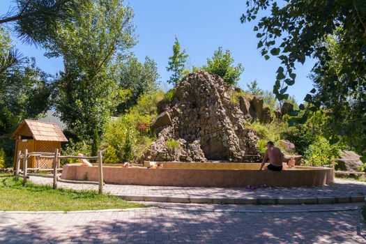 the nature of the hill is laid out of stone and tourists are resting on their background