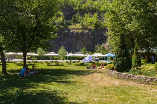 A place for tourists to relax in the form of tents and sun beds with umbrellas against the backdrop of a rocky mountain