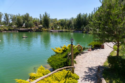 stone banks of a large lake with planted decorative bushes for recreation of tourists