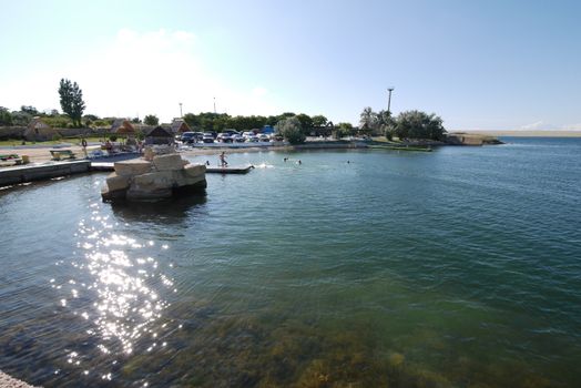 The blue of the coastal, sea, salt water through which the sandy bottom can be seen