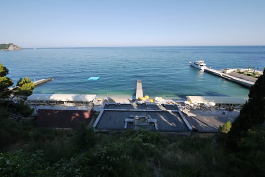 The coastal zone with three piers to one of which is moored a small white boat