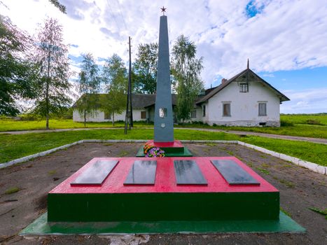 Several memorial plaques next to a high commemorative monument with a star