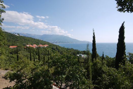 Beautiful houses with red roofs on the coast of the endless blue sea and majestic mountains