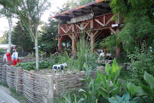 Figures of Cossacks and cows behind a wicker fence at the entrance to an authentic Ukrainian restaurant