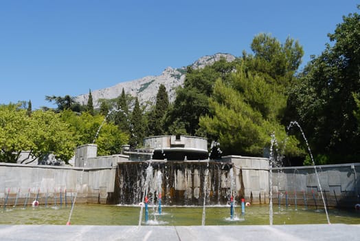 fountains with clear water on the background of trees and the mountains far away