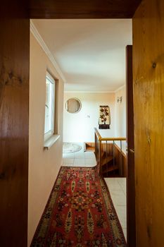 A small corridor in the room with a track on the floor leading to the steps along which you can go down to the floor below.