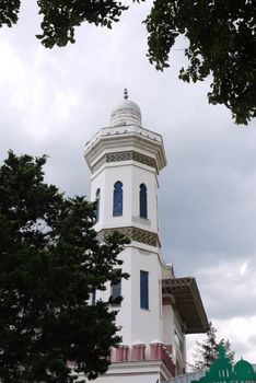 High rectangular eastern building with oblong windows and ornaments against the blue sky