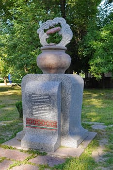 small neat monument with an inscription and ornament standing on a green meadow