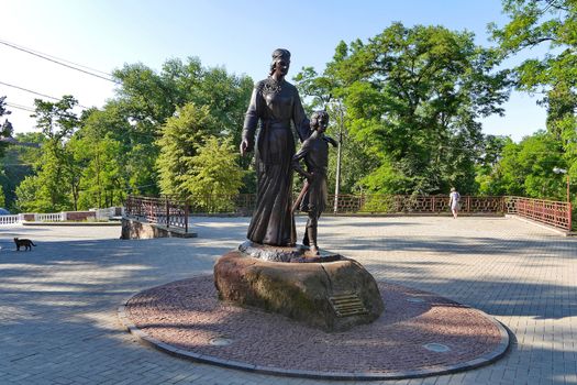 Bronze monument of mother and boy. And the cat watches him