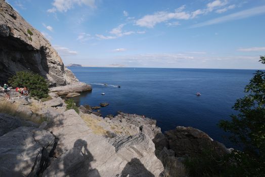 An observation deck in a cave in a rock on the shores of the blue sea, with a magnificent landscape