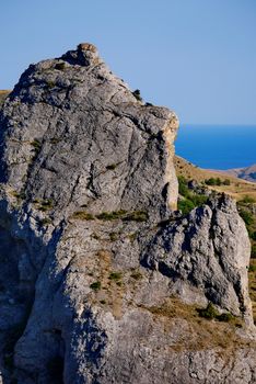 Scenic view from a large rocky mountain mountain to a huge transparent blue sea