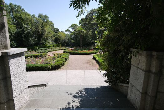 Stone steps leading to a small decorative square with a round flower bed in the middle