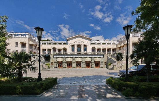 Magnificent view of the palace with beautiful architecture and white walls with stairs from both sides leading to the second floor standing in a park with picturesque nature.