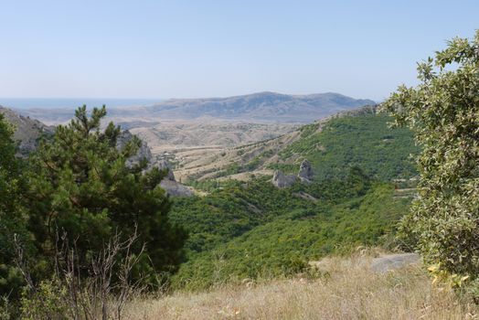 landscape of dry mountain ranges in front of the sea gulf in the distance