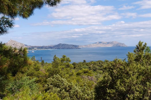 sea bay with winding coastline on the background of high mountains under cloudy sky