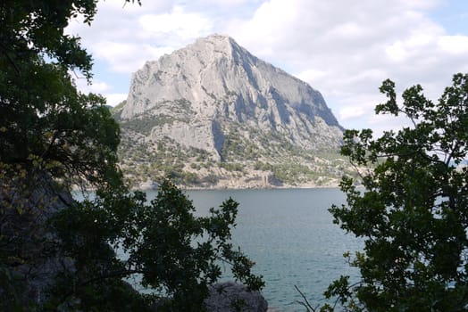 Orgonal rocky gray mountain against the background of the vast blue sky