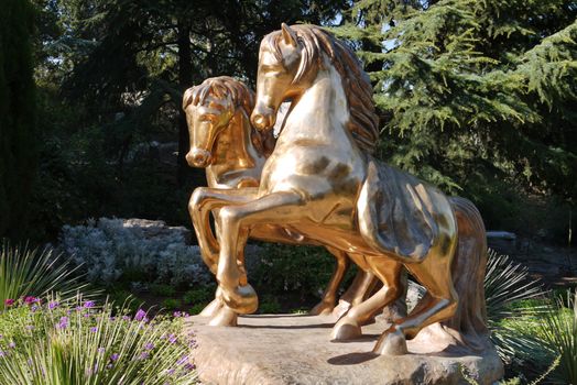 A monument with two golden horses shines from the sun