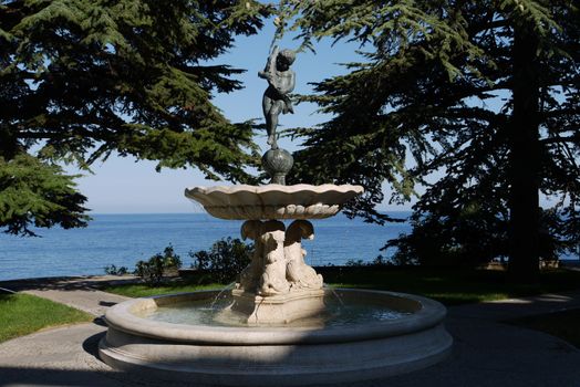 fountain boy with a fishfrom high cedar against the background of the boundless blue sea