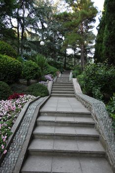 alley with stone staircases and lanterns in a park with green trees