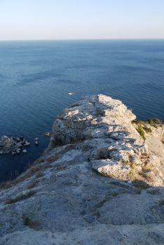 a steep grass-covered slope on the background of a beautiful boundless sea