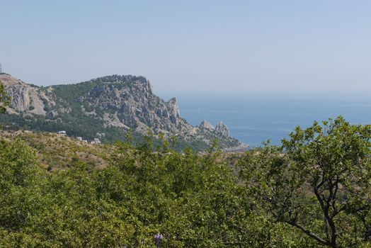 grass slopes on the background of high steep cliffs and the boundless black sea