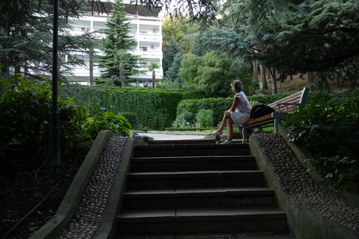 Go up the park to the white house through the alley in a park with beautiful landscape design