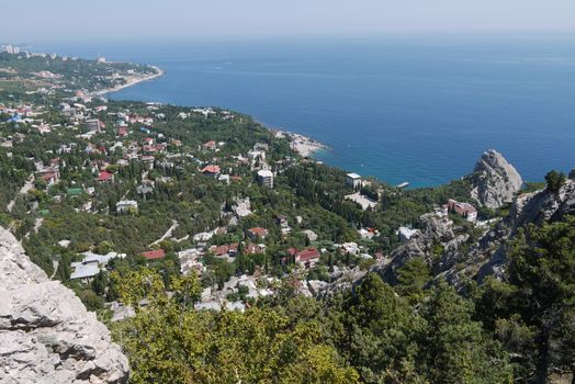 a small rock on the background of a beautiful quiet coastal town under a blue sky