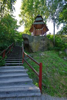 small narrow stairs leading to a gazebo surrounded by tall trees