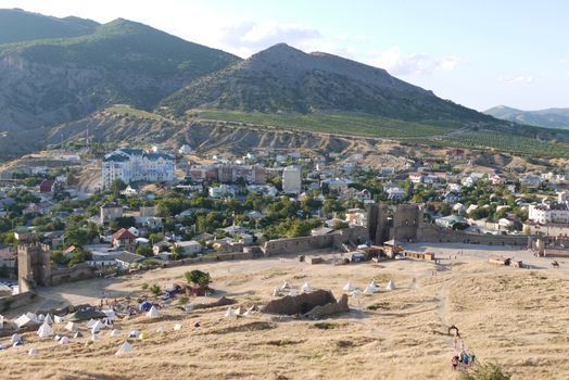 a small cozy town on the background of high slopes covered with grass