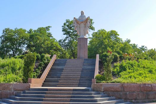 Stairs leading to a low monument against the background of high dense trees