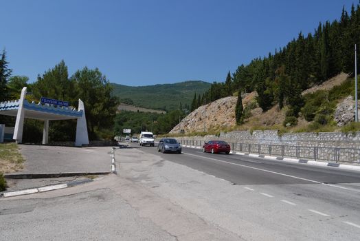 a long road against the background of high mountains covered with trees