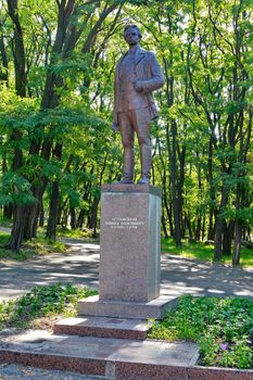 a tall monument to the famous writer on the background of wide green trees