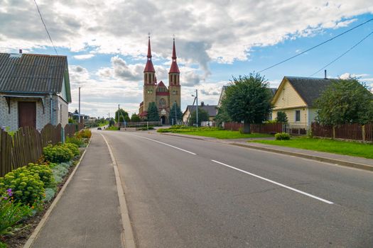 small houses on the background of a tall church with a red roof