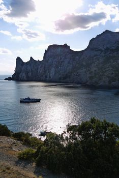 bay in the black sea on the background of steep cliffs covered with grass. Walking on a boat