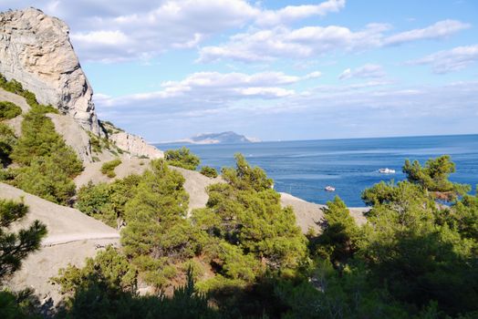 Beautiful Crimean mountains are covered with trees on the background of a deep black sea