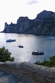 bay in the black sea on the background of steep cliffs covered with grass. Walking on a boat