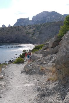 a long narrow road under high Crimean rocks against a blue sky background.Walking in the nature