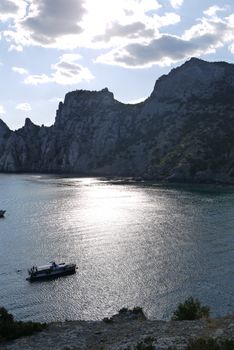 bay in the black sea on the background of steep cliffs covered with grass. Walking on a boat