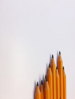 Group of yellow pencils on a white plane